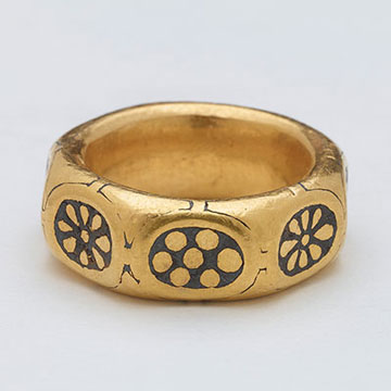 A unique gold octagonal finger ring dated to the 9th century with black niello rosette and flower motifs on each of the eight facets. It is decorated with in the Anglo Saxon 'Trewhiddle' style.
